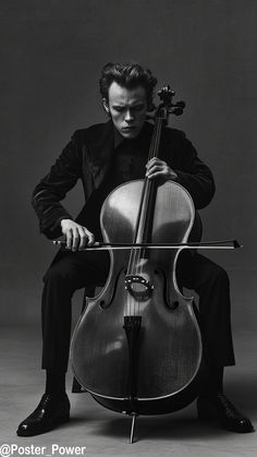 a man sitting on top of a chair holding a cello