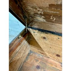 the inside of an old wooden structure with peeling paint and wood planks on it