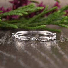 a close up view of a wedding ring on a table with flowers in the background