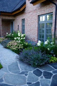 a brick house with stone walkway leading to the front door