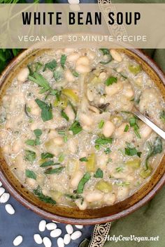 white bean soup in a brown bowl with spoon and green leaves on the table next to it