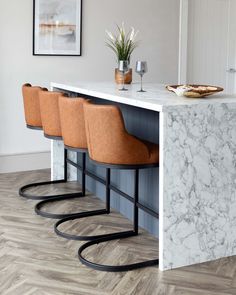 a kitchen with marble counter tops and bar stools