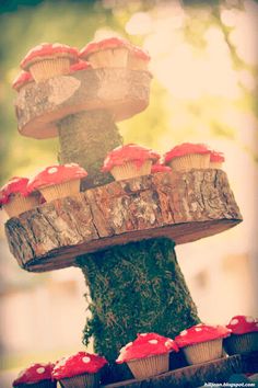 cupcakes are stacked on top of a tree trunk and placed in the shape of a mushroom