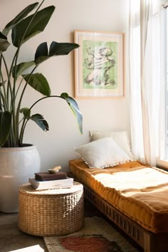 a bed sitting next to a window in a bedroom under a painting on the wall