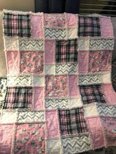 a pink and black quilt on top of a bed