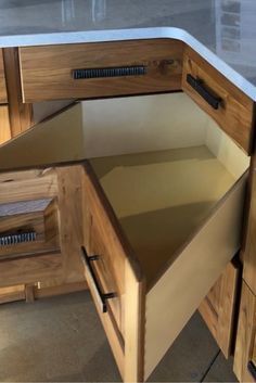 an open drawer in the middle of a kitchen counter top with drawers on each side