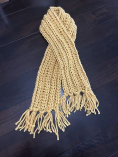 a knitted scarf laying on top of a wooden floor