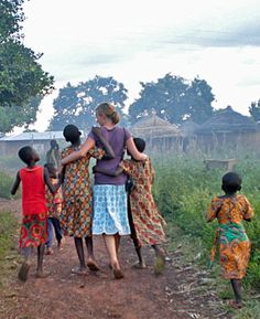 a group of people walking down a dirt road