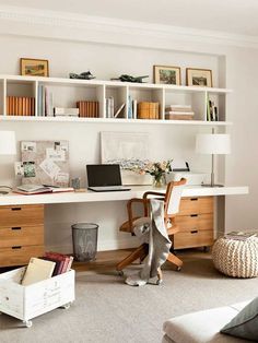 a desk with a laptop on top of it in front of some bookshelves