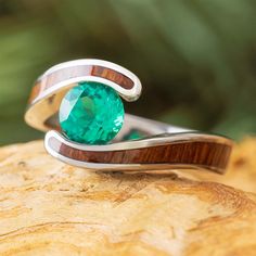 a close up of a ring with a green stone