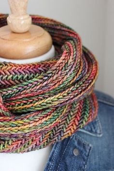 a close up of a mannequin wearing a multicolored knitted scarf