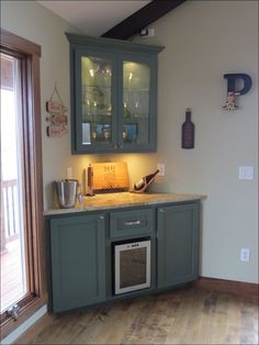 a kitchen with green cabinets and wooden floors