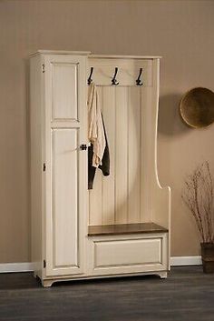 a white wooden bench sitting under a coat rack