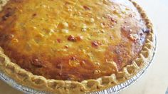 a pie sitting on top of a table covered in cheese