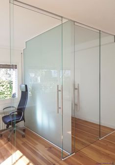 an office with glass walls and wooden floors