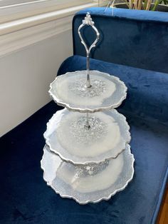 three plates stacked on top of each other in front of a blue velvet couch with white trim