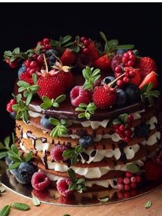 a layered cake with berries and chocolate frosting