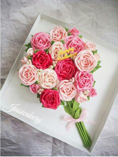 a bouquet of pink and red roses on a white tray