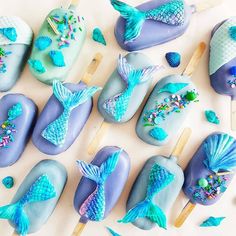 there are many blue and purple treats on the table, including one with a mermaid tail