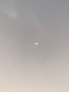 an airplane is flying in the sky with a half - moon visible above it,