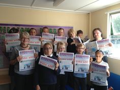 a group of people holding up newspapers in front of a window with pictures on them