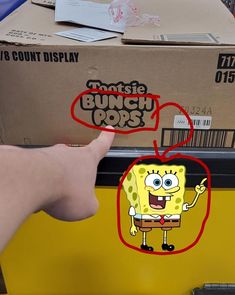 a hand pointing at a box with an image of a spongebob on it