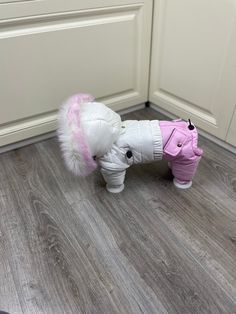 a small white and pink toy elephant on the floor