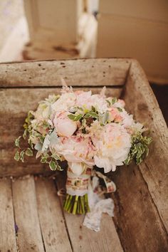 a bridal bouquet sitting on top of a wooden crate