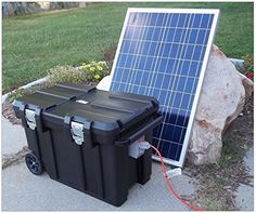 two coolers sitting next to each other on the ground with a solar panel behind them