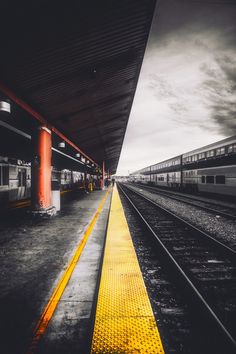 an empty train station with two trains on the tracks