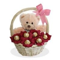 a teddy bear sitting in a basket filled with chocolates