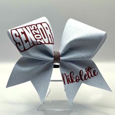 Get ready to elevate your game with our dazzling Custom Glitter Senior Cheer Bow! 🌟 Whether you're shaking things up on the sidelines or dazzling the crowd with your routines, this bow is your ultimate cheer companion! 🎉 Customizable Glamour: Choose from a rainbow of glittery hues to match your team colors or showcase your unique style! From bold blues to radiant reds, we've got the shade to make you stand out! 💎 Shine Bright with Rhinestones: Our bows aren't just about glitter--they come wit Senior Cheer Bow Ideas, Senior Bows, Senior Cheer Bows, Competition Cheer Bows Rhinestones, Senior Sash, Cheer Bows With Rhinestones, Cute Cheer Bows, Sparkly Cheer Bows, Silver Cheer Bows