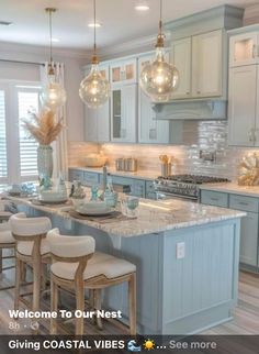 a kitchen filled with lots of counter top space and lights hanging from the ceiling above it