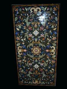 an intricately designed door with flowers and leaves on it's side, in the dark