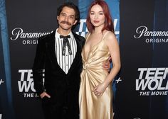 a man and woman standing next to each other on a red carpet at an event