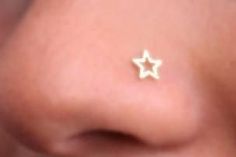 a woman's nose with small gold stars on it