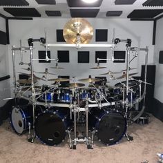 a drum set up in a room with black and white walls