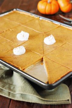 a pan filled with pumpkin pie on top of a wooden table