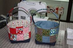 two baskets sitting on top of a table next to a sewing machine