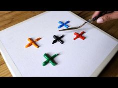 someone is using scissors to cut out small plastic airplanes on a piece of white paper