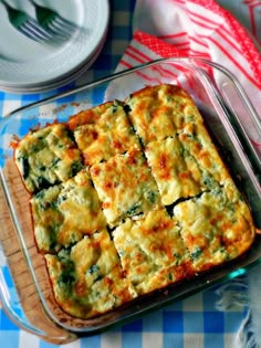 a casserole dish with spinach and cheese in it on a blue checkered table cloth