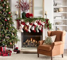 a living room decorated for christmas with stockings on the fireplace