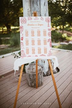 an easel with a sign on it sitting in front of a wooden tree trunk