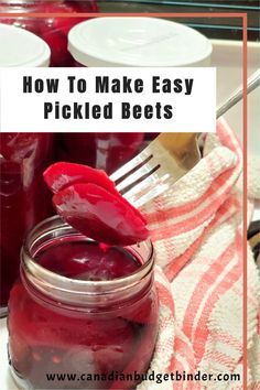 jars filled with pickled beets sitting on top of a table next to utensils