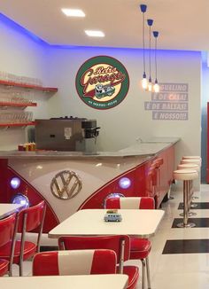 the interior of a restaurant with red and white tables, chairs, and counter tops