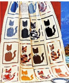 a crocheted blanket with cats on it