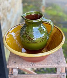 a green and yellow bowl sitting on top of a wooden table