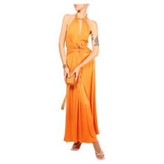 a woman in an orange dress is standing with her hands on her hips and looking off to the side