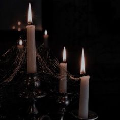 a group of lit candles sitting on top of a table next to a candle holder