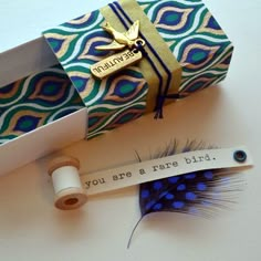 an open gift box with a feather inside and a note attached to it that says, you are a rare bird